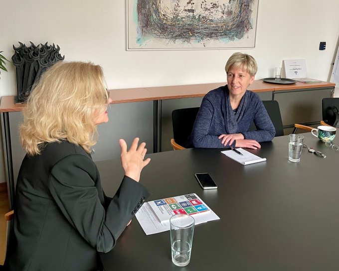 Zwei Frauen an einem Tisch sitzend und redend